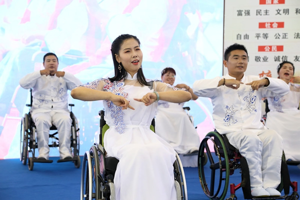 “中国好人”肖卓作(左二)带领“轮友”们在台上表演手语舞《让世界充满爱》.jpg